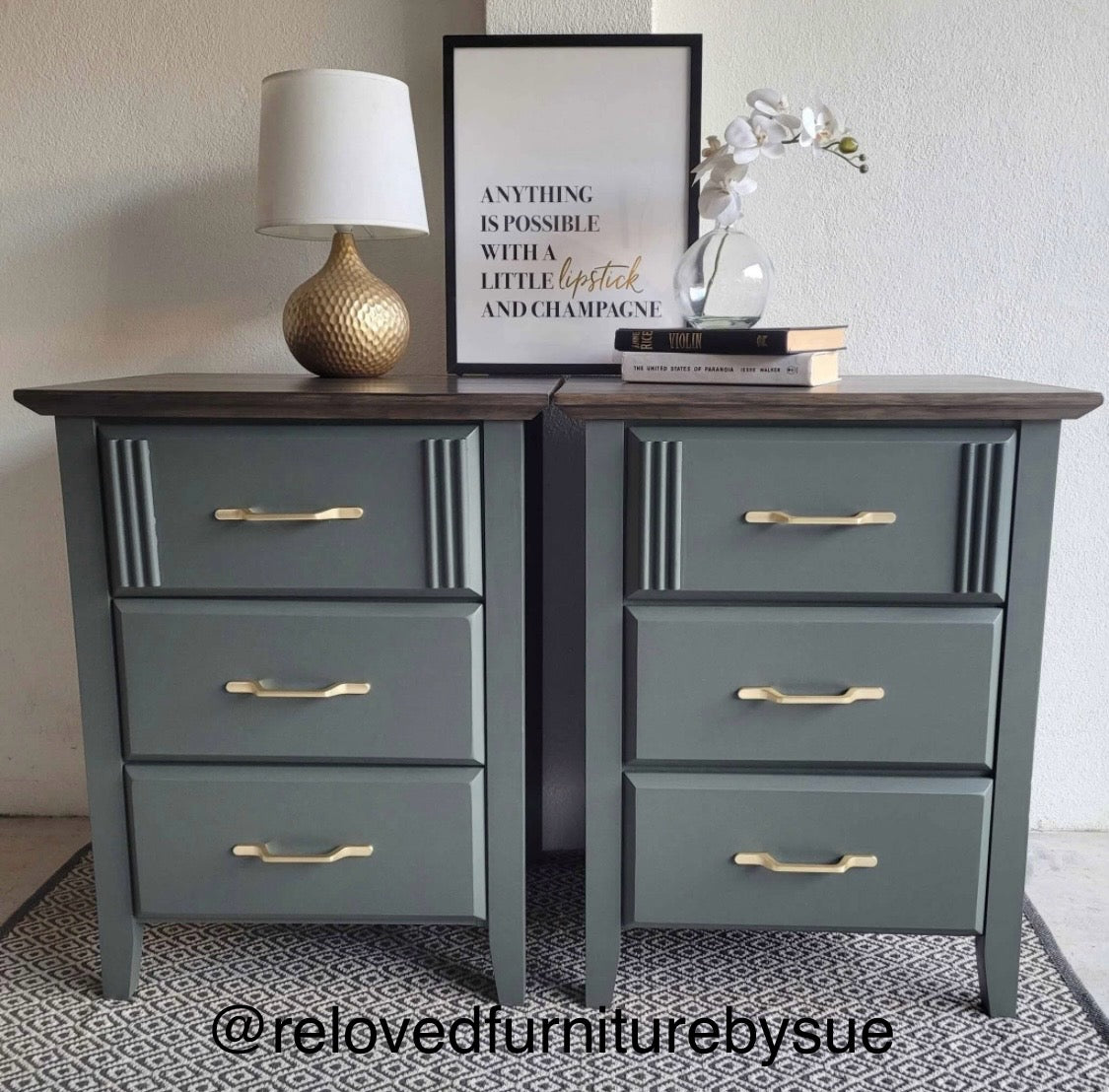 Gren nightstands with gold handles on a patterned rug, featuring a lamp and framed quote.