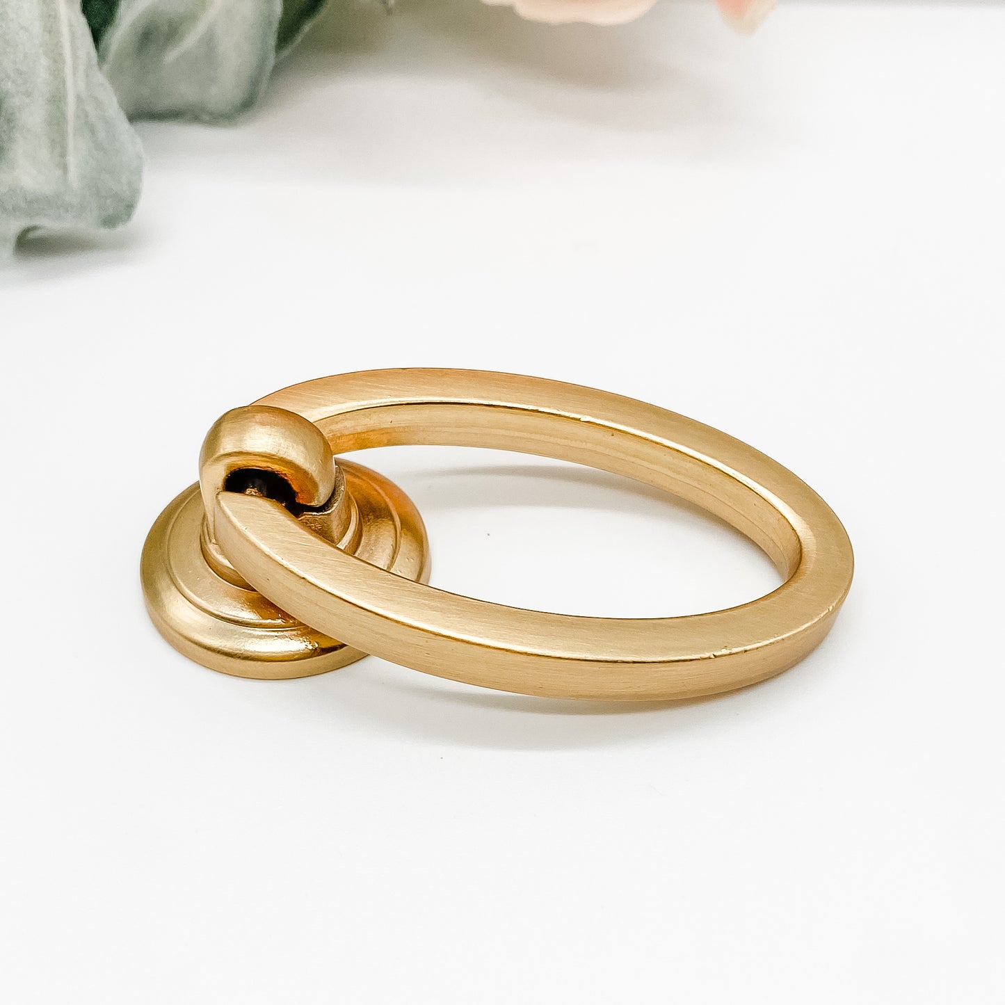 brushed gold oval shaped drop ring pull for cabinet drawers side angle on white background