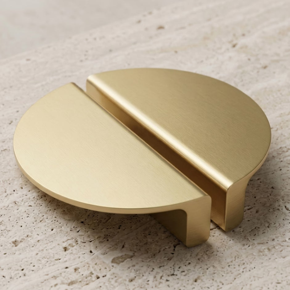 Gold half moon handles on a textured stone benchtop