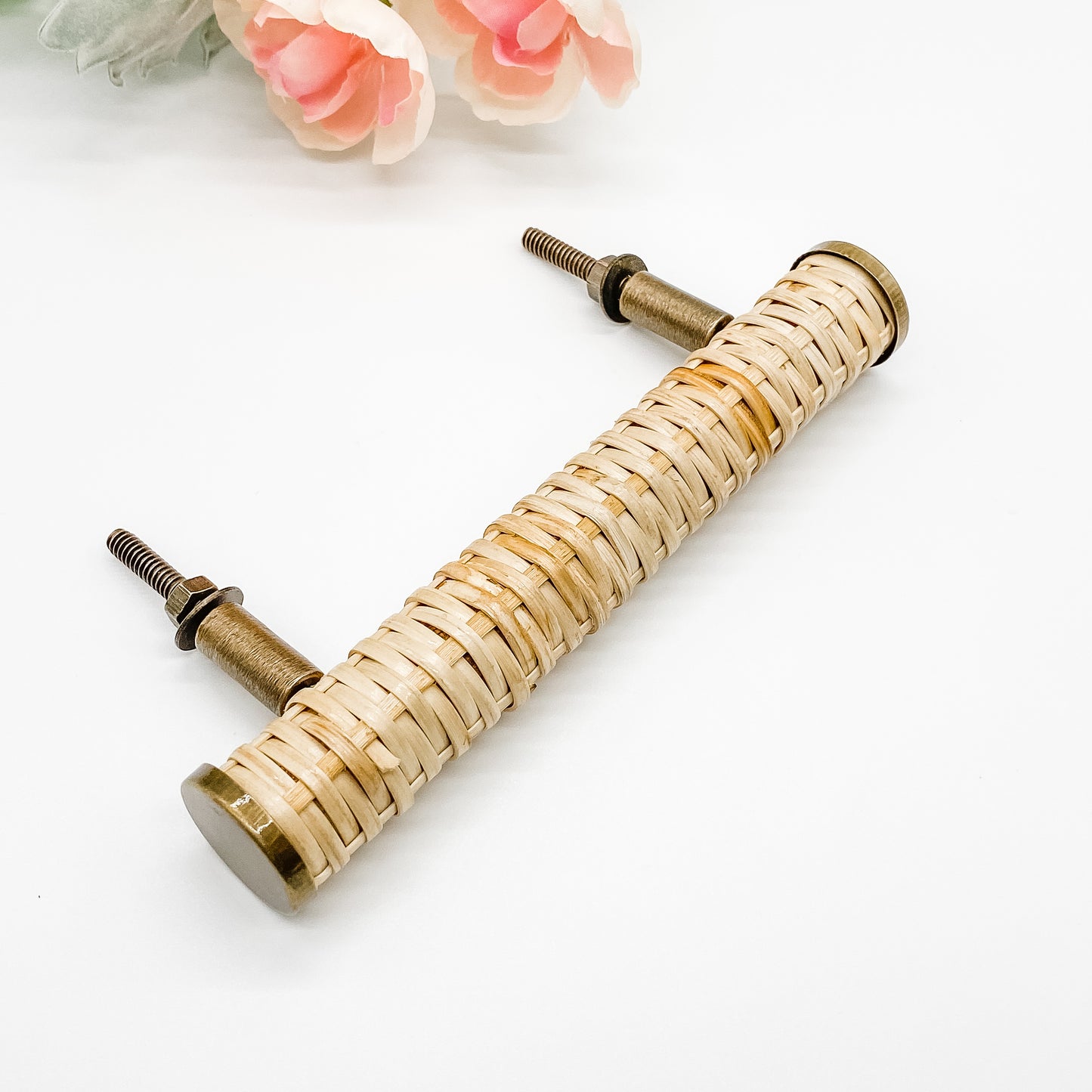 140mm long round rattan cabinet handle with brass edges on white background side angle