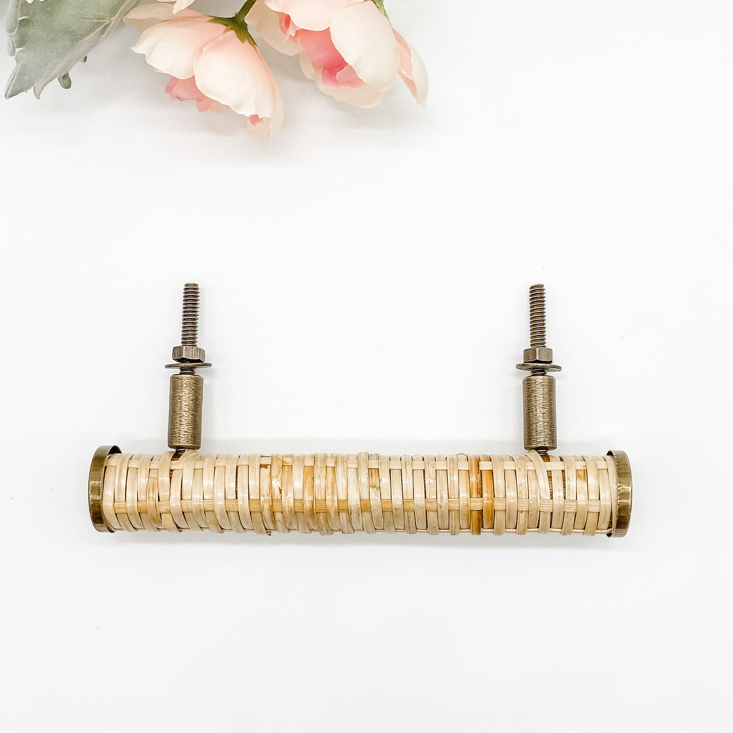 long round rattan cabinet handle with brass edges viewed from above on white background
