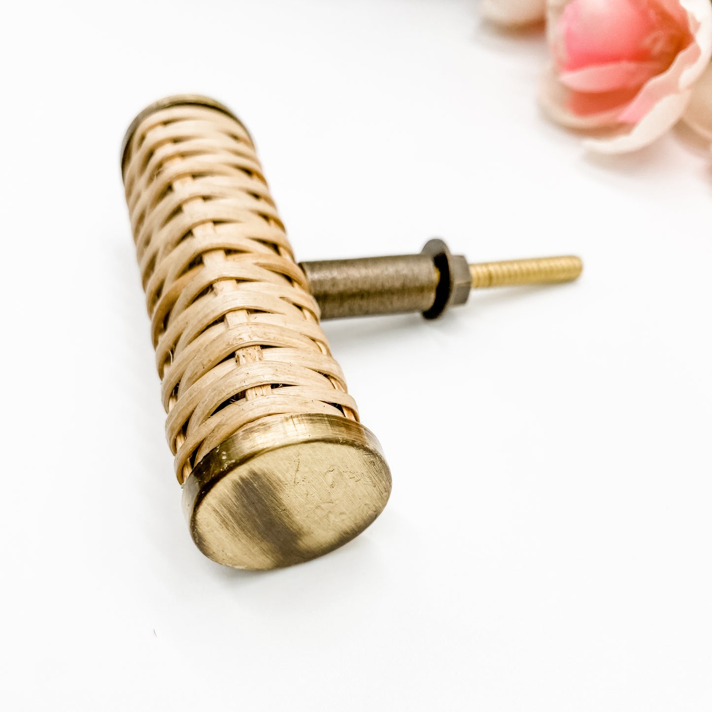 small rattan handle with brass edges t-bar style on white background side angle