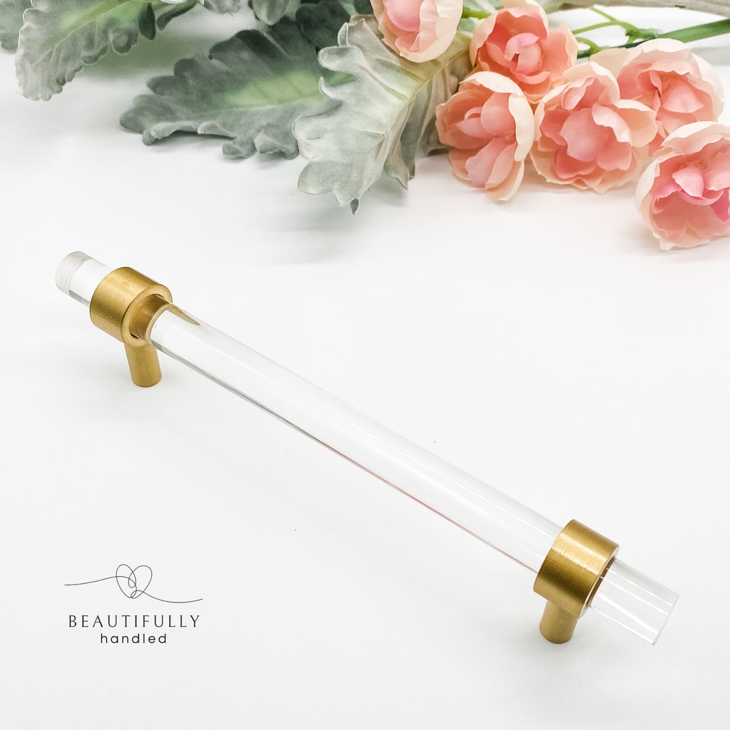 clear drawer handle with gold clasps on white background