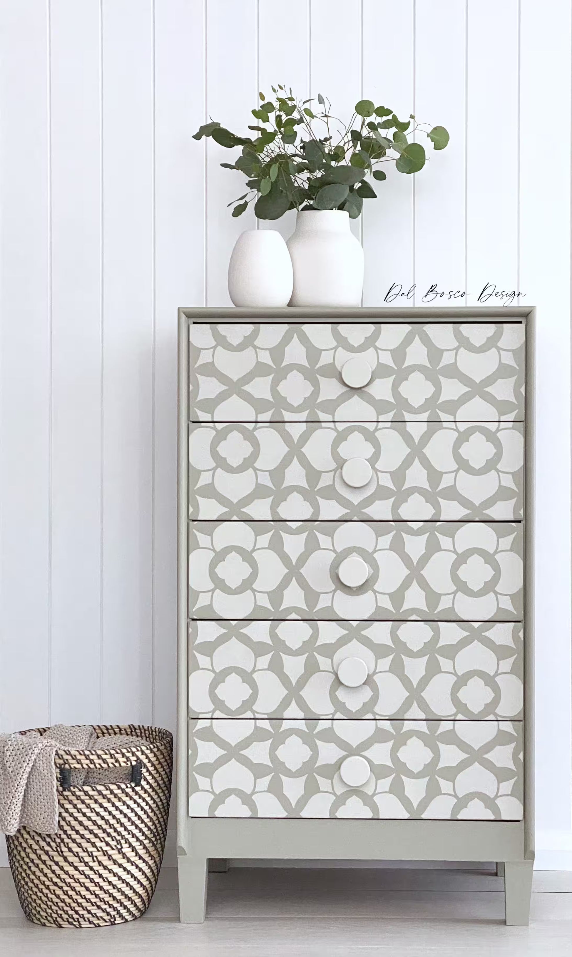 stencilled alrob chest of drawers with white 50mm wooden drawer knobs with woven basket against white wall