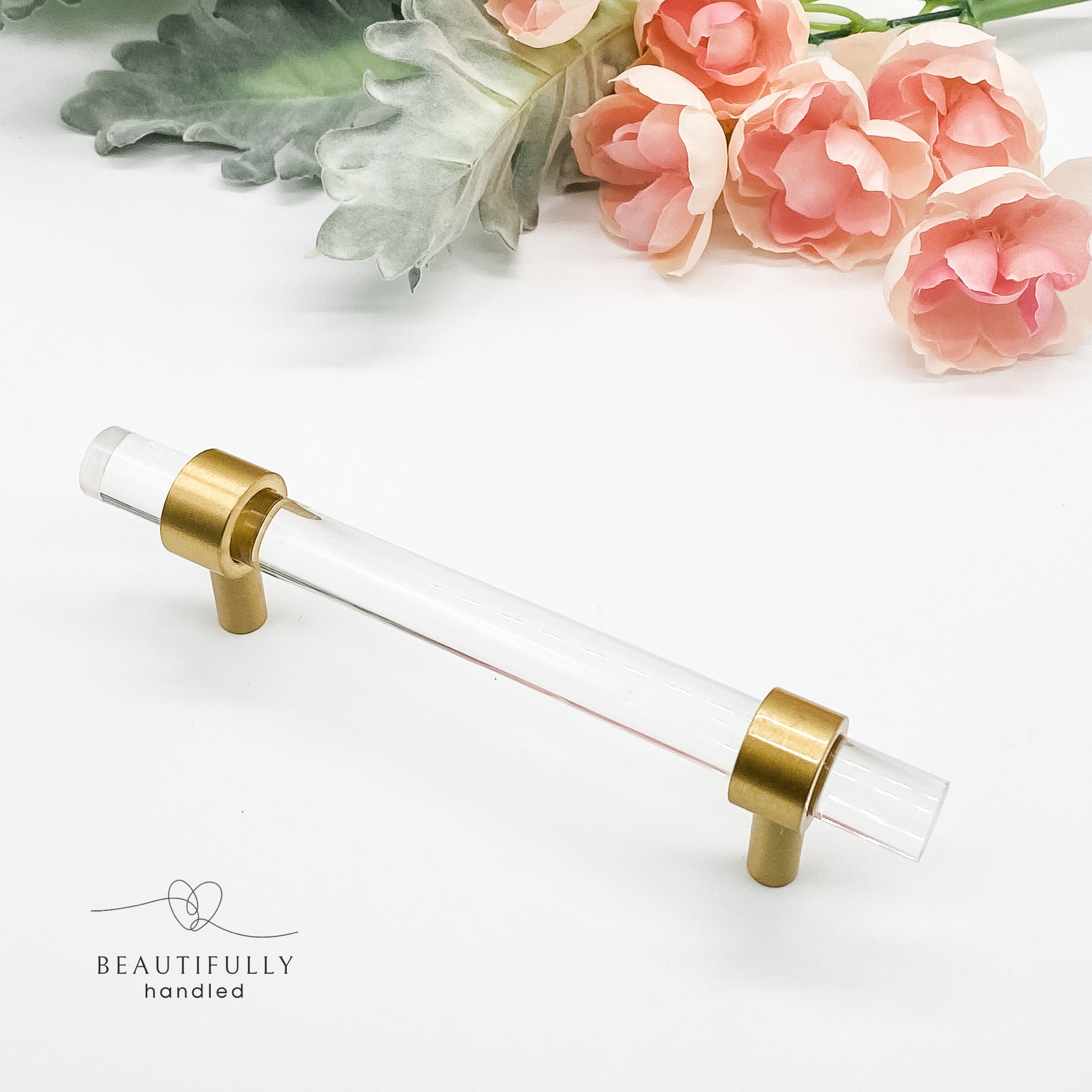 14cm long clear drawer handle with brass feet on white background
