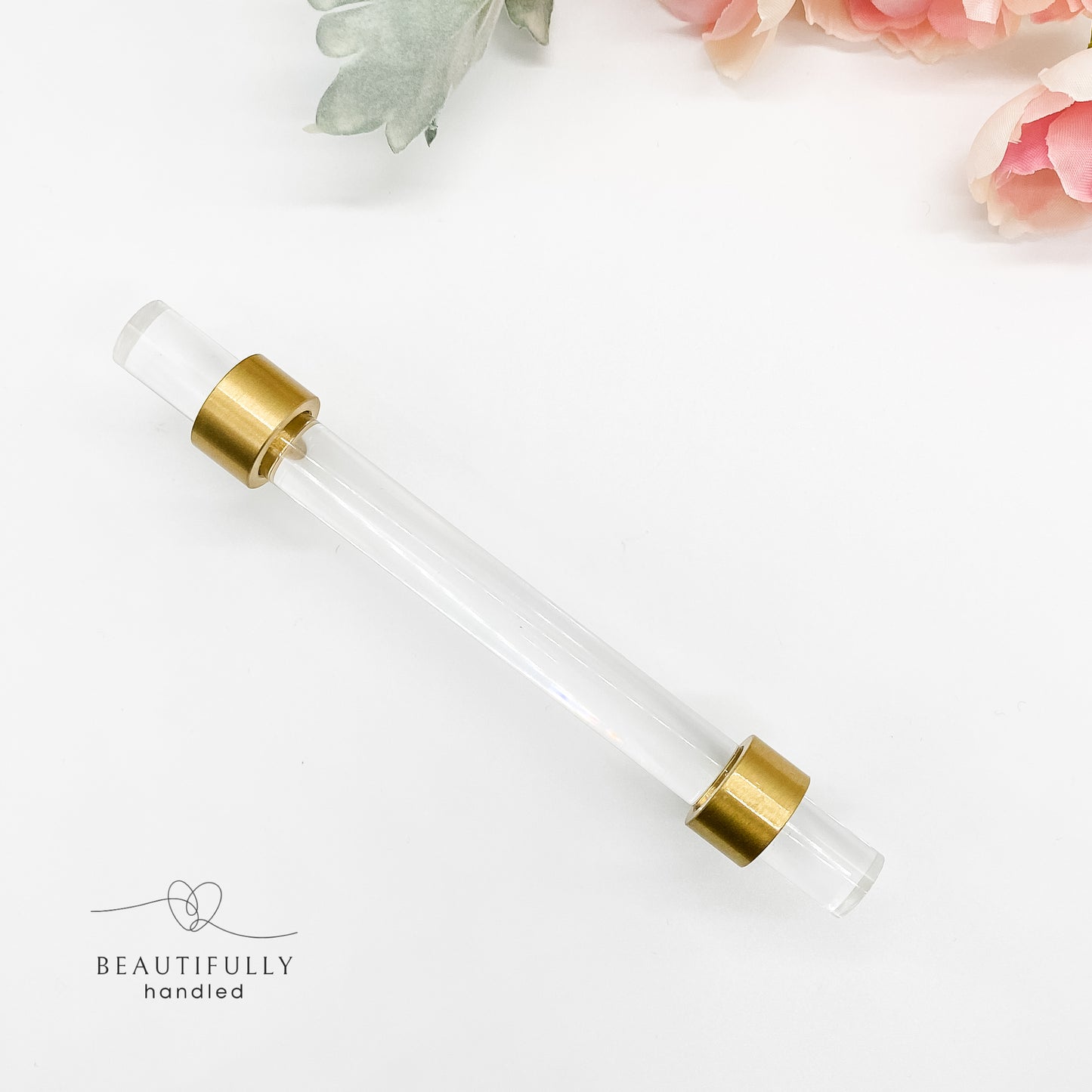 96mm clear kitchen handle with brushed brass feet on white background