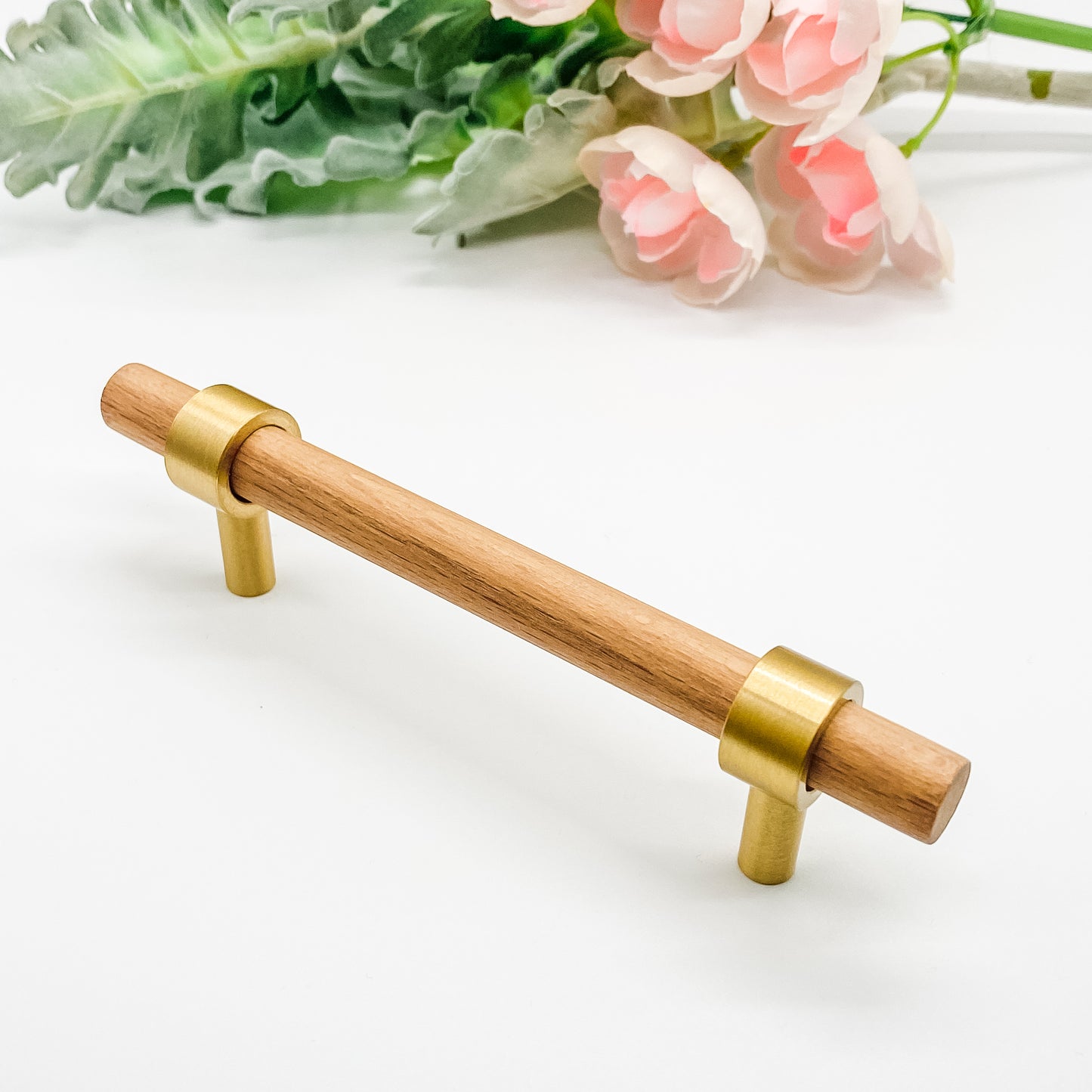 Wooden handle 96mm with brass accents on a white background with flowers.