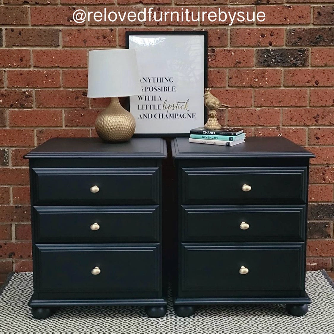 pair of black bedside tables with brushed gold knobs in front of brick wall and textured rug
