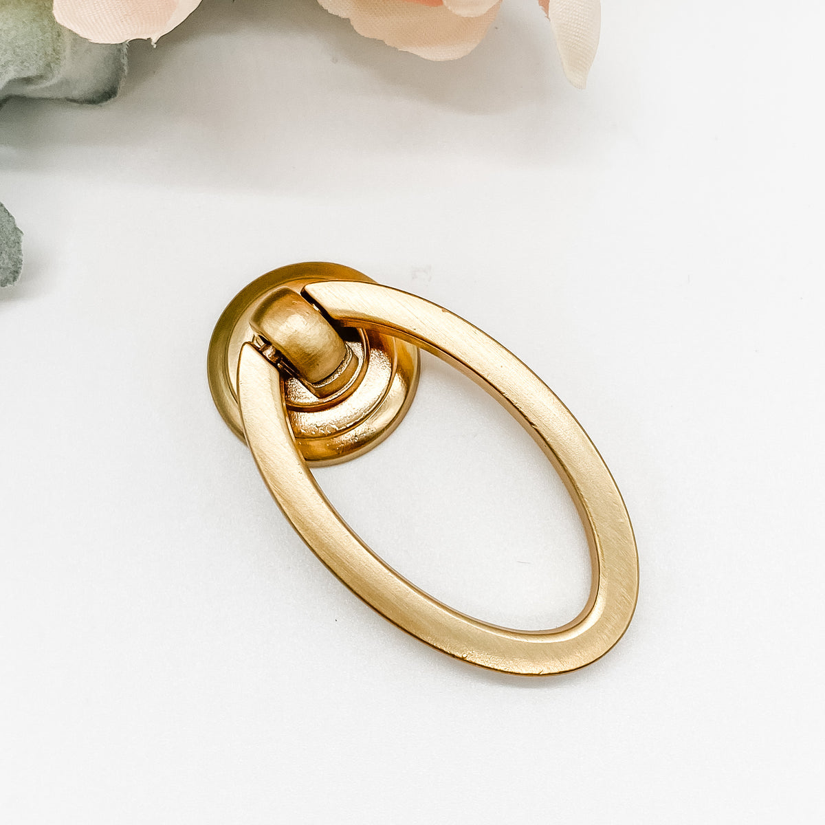 brushed gold oval shaped drop ring pull for cabinet drawers front angle zoomed on white background