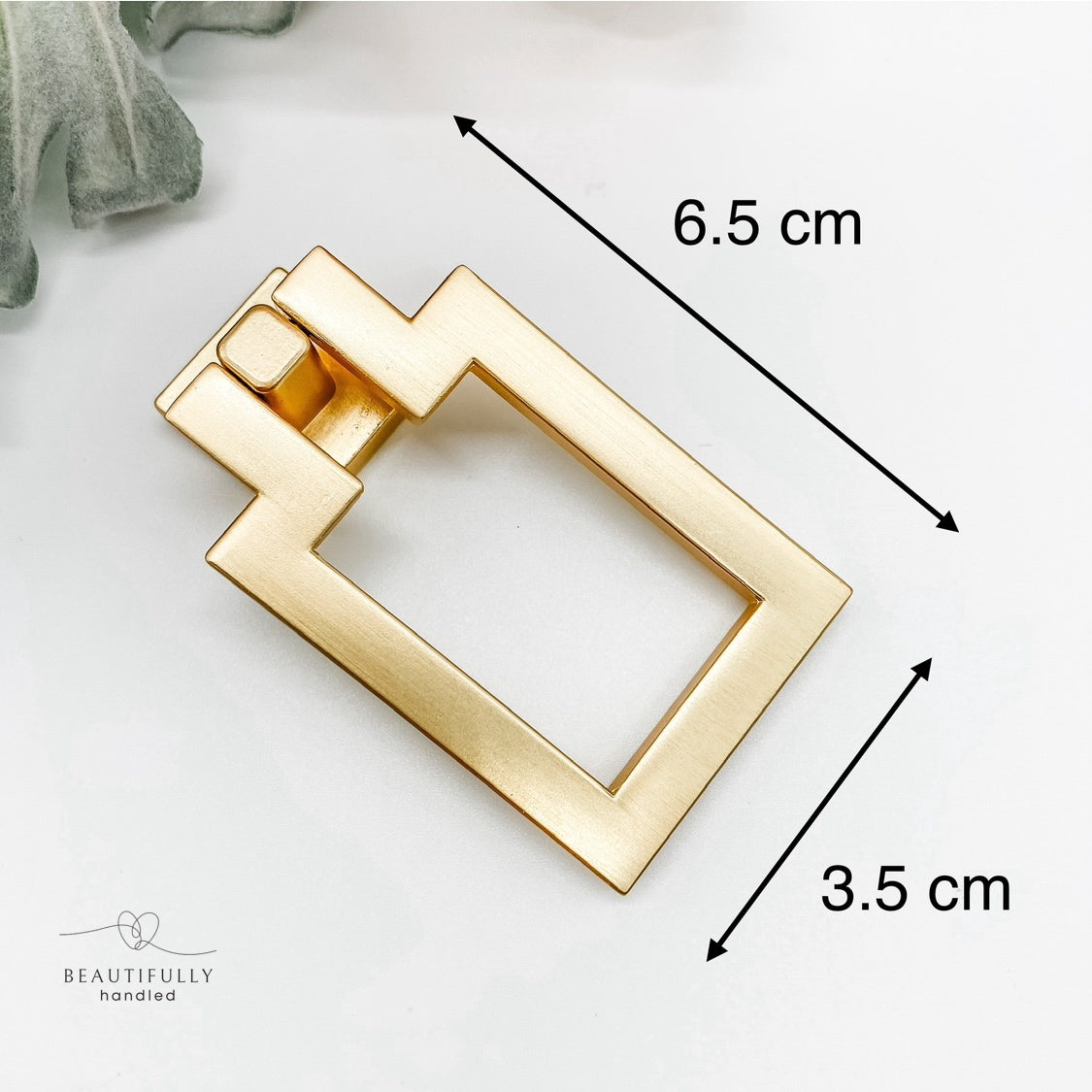 gold rectangle shaped drop pull cabinet handle on front angle with dimensions on white background