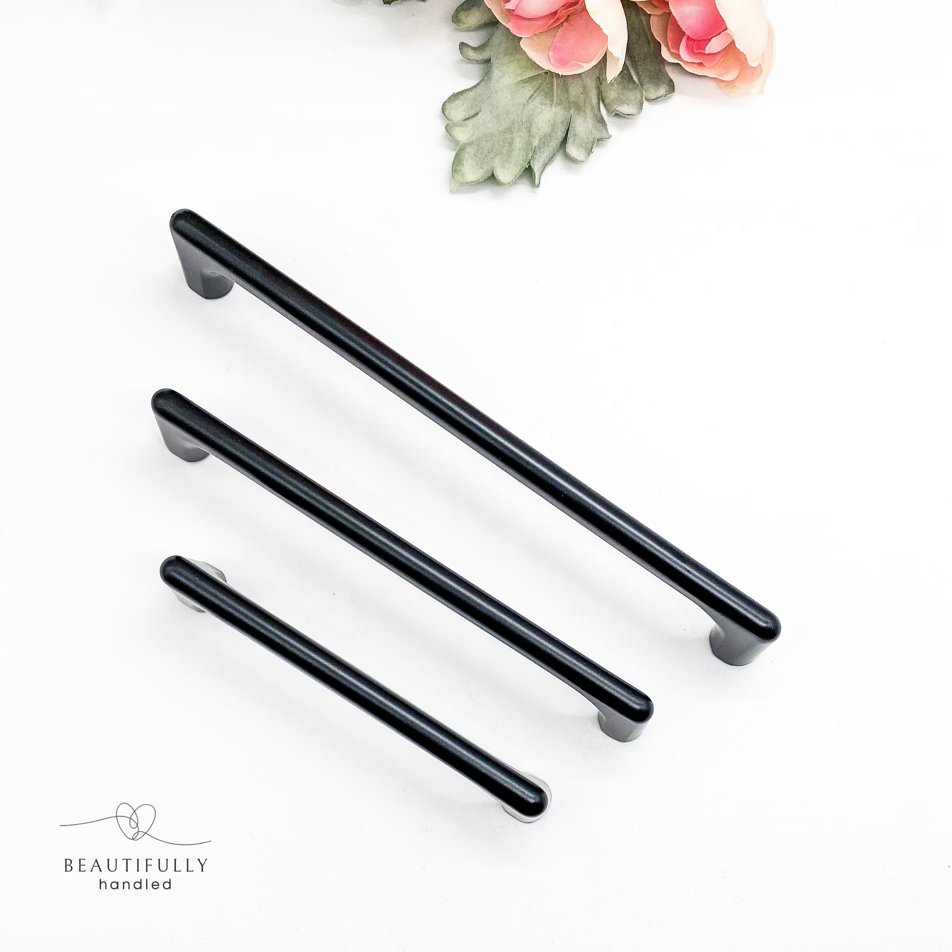 Black cabinet handles on a white background top view.