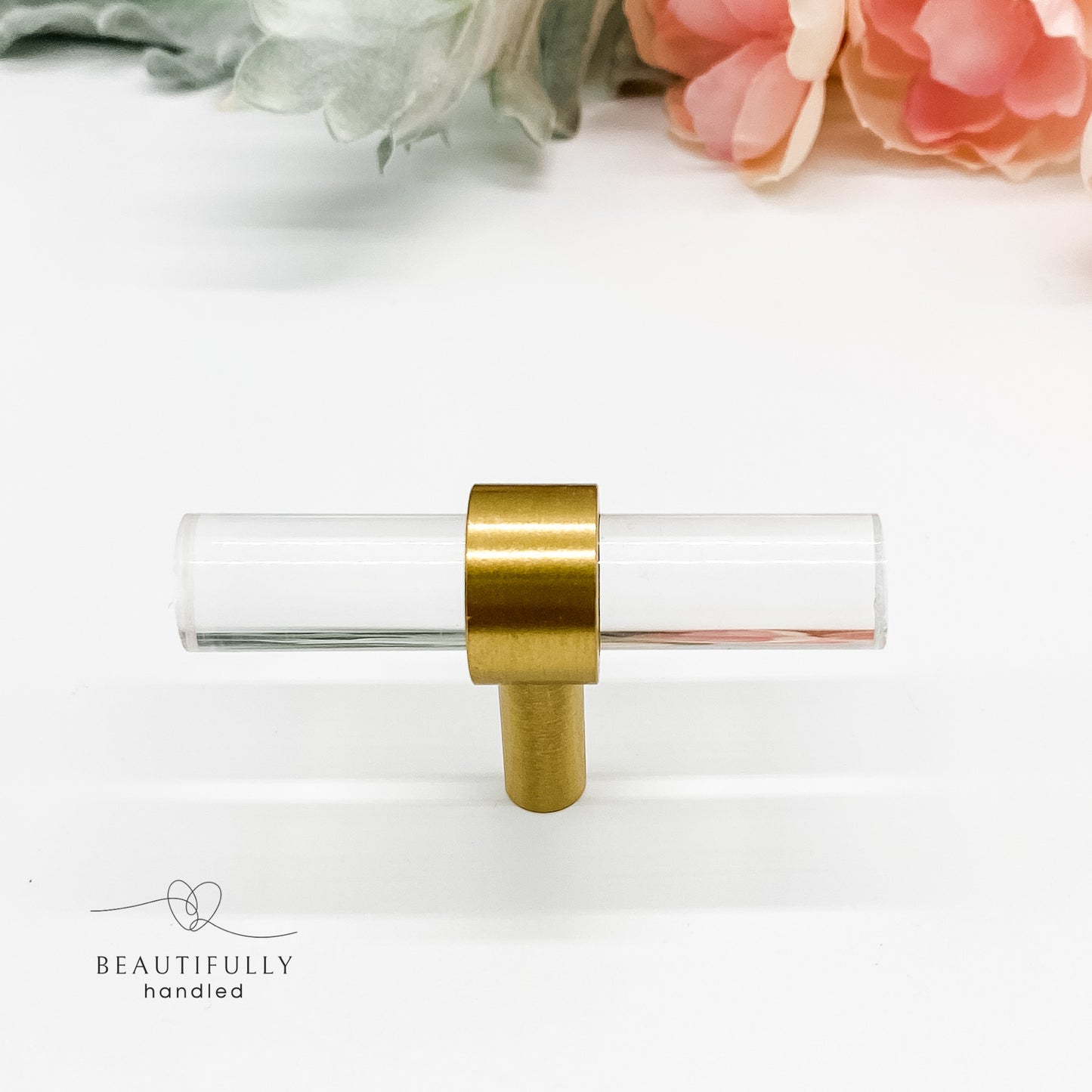 clear drawer knob with brass accent on white background