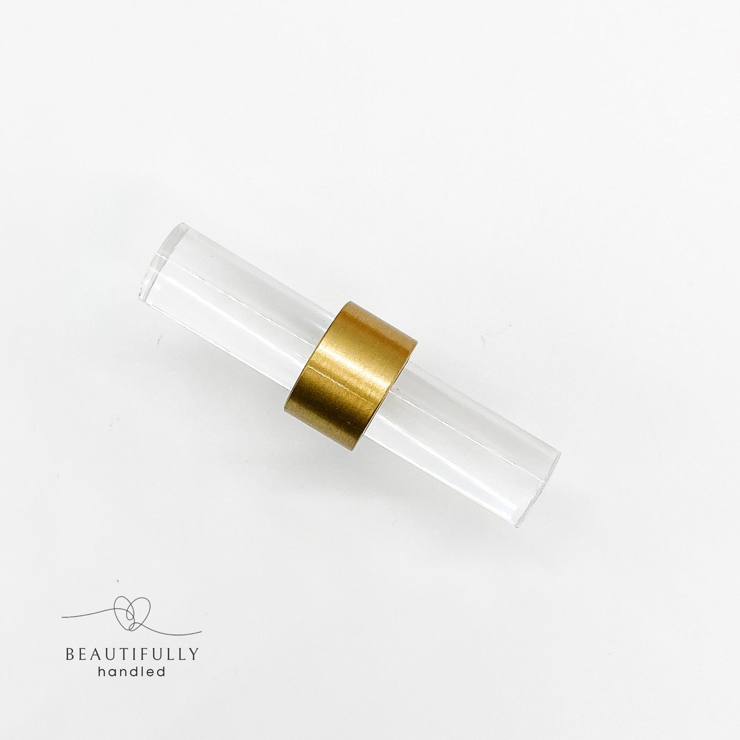 close up of clear acrylic handle with brass clasp on white background