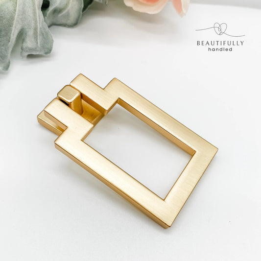 Gold rectangular drawer handle on a white background with 'BEAUTIFULLY handled' branding.
