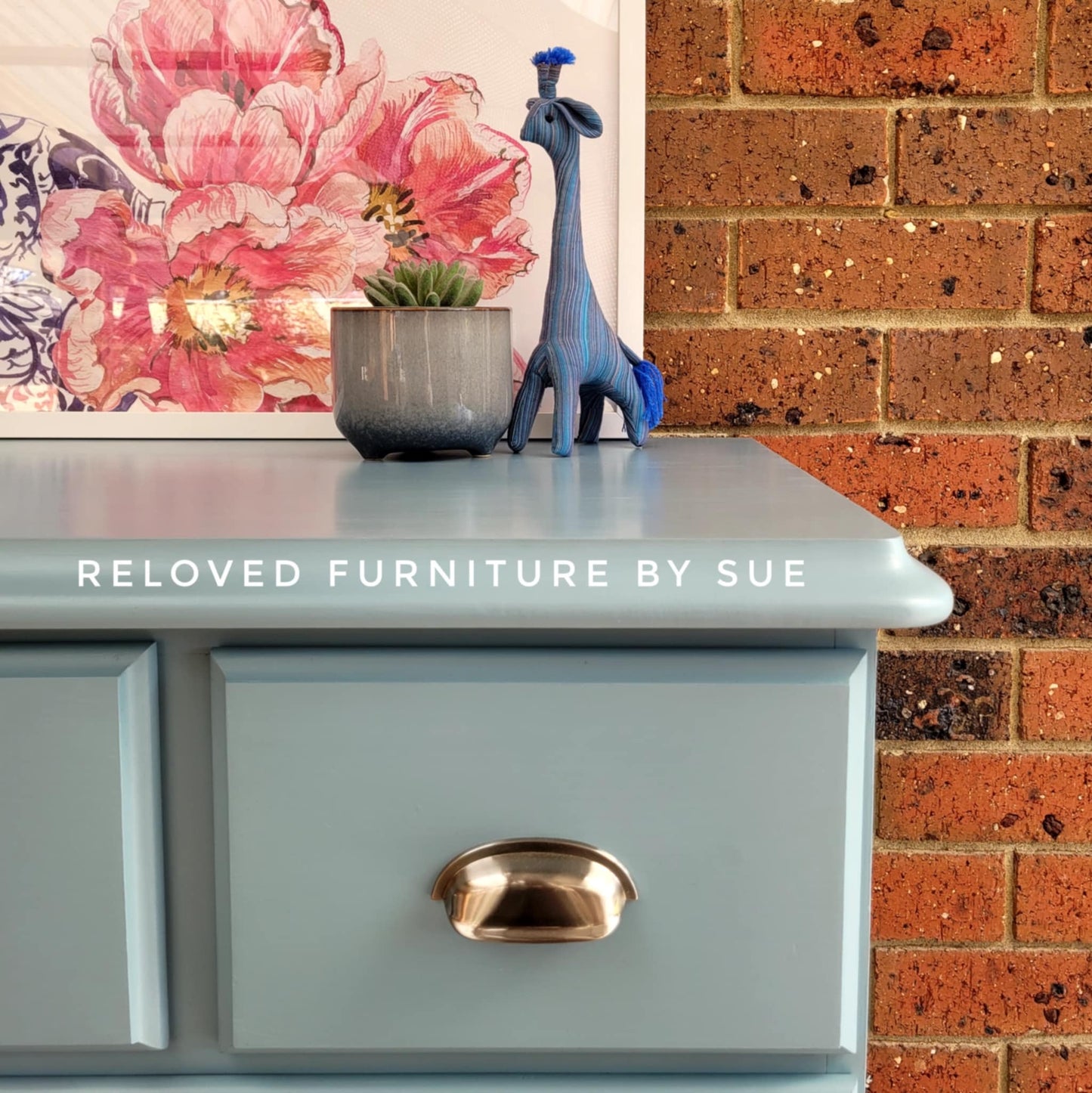 close up of chrome cup pull hamptons style on blue drawers