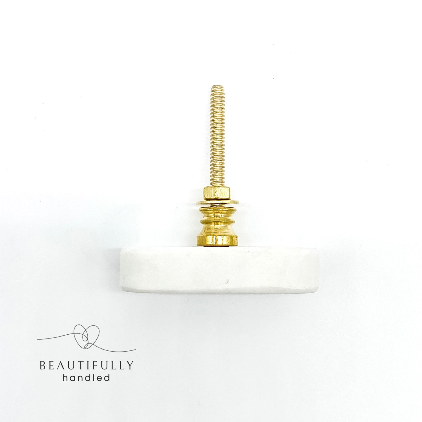 overhead image of oblong shaped marble drawer handle on plain white background
