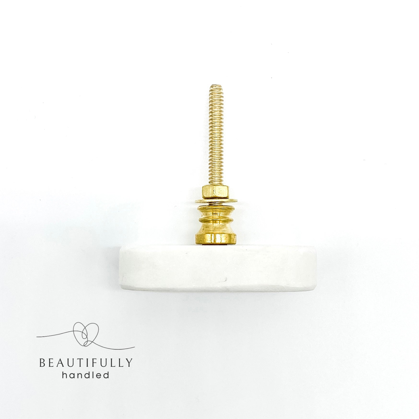 overhead image of oblong shaped marble drawer handle on plain white background