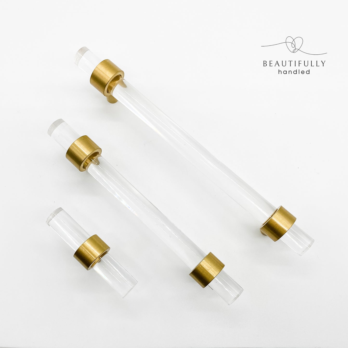 clear drawer handles with brass feet in 3 sized on white background