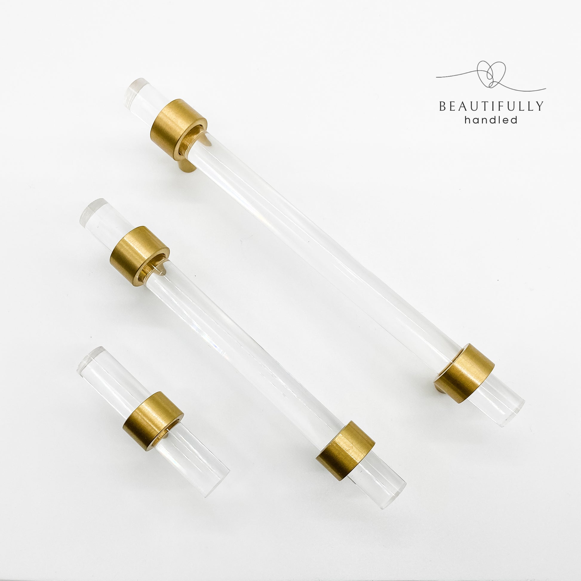clear drawer handles with brass feet in 3 sized on white background