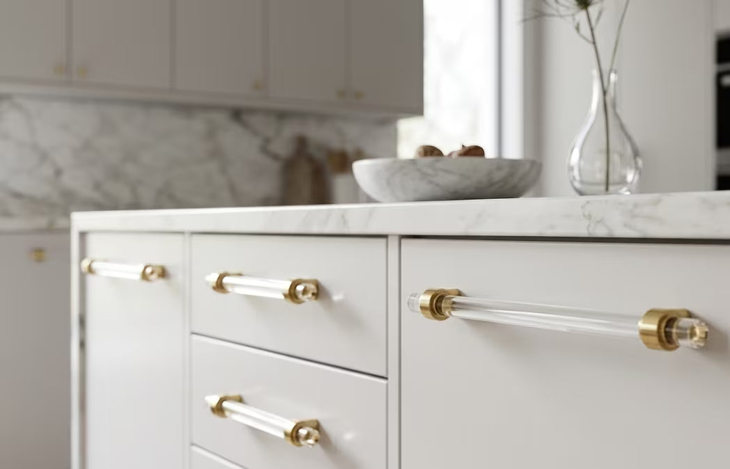 White kitchen cabinets with acrylic and gold handles and marble countertop