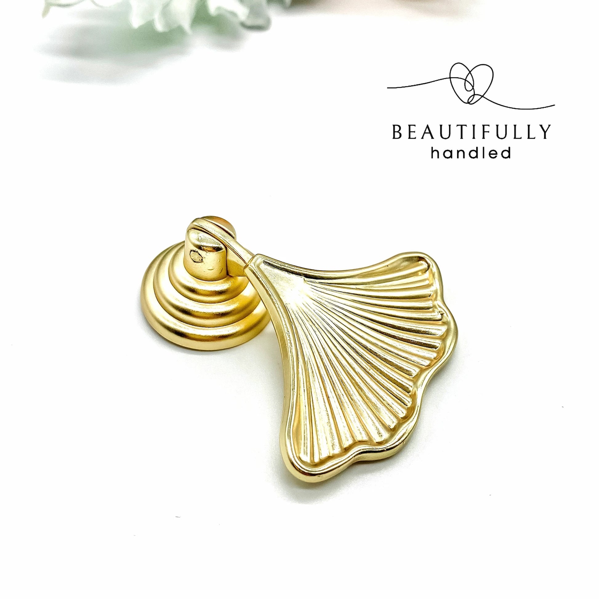 gold ginkgo leaf shaped handle on white background