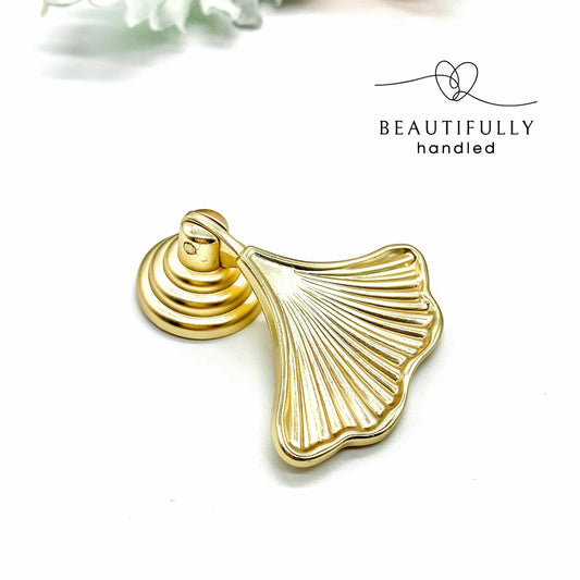 gold ginkgo leaf shaped handle on white background