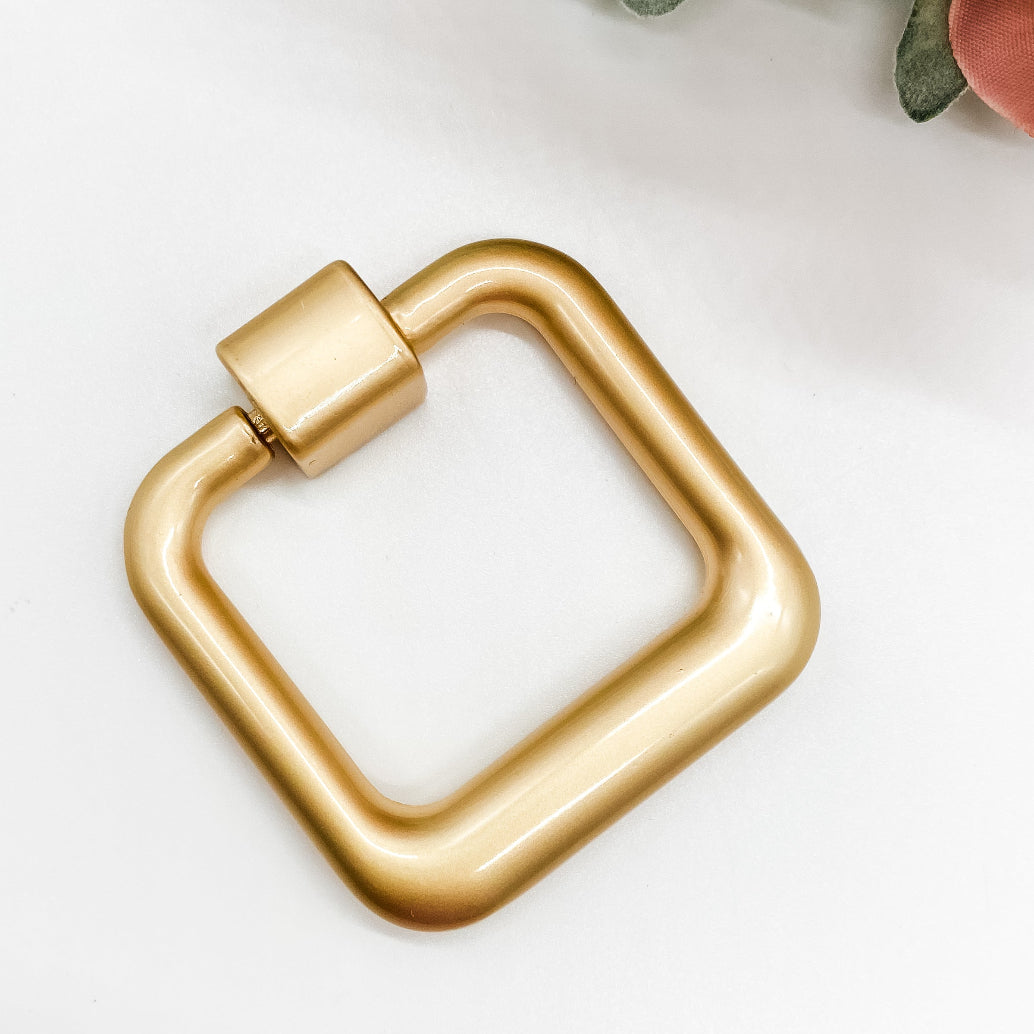 Gold square drop pull handle on white background