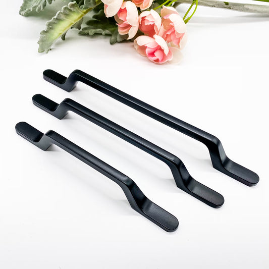 Three black cabinet handles on a white background with pink flowers and green leaves.