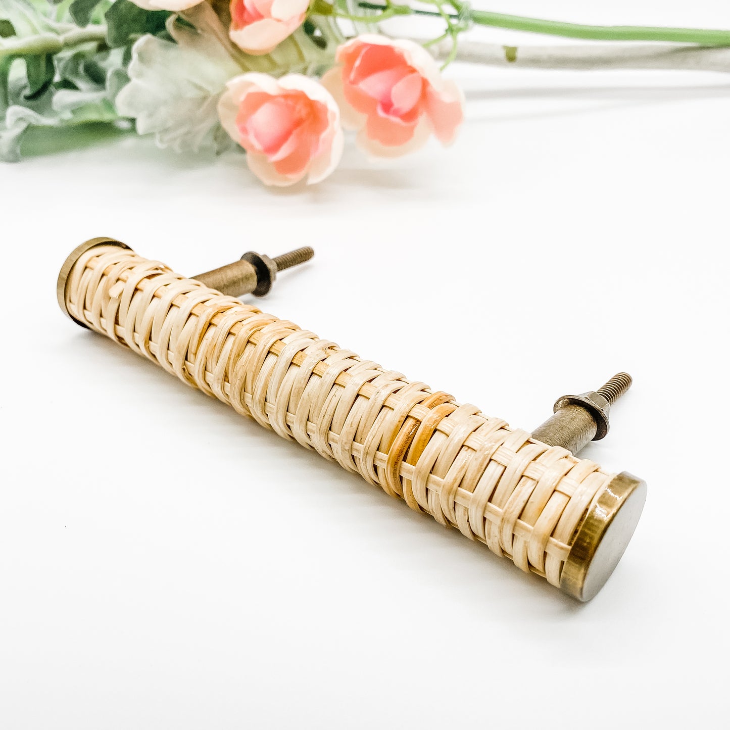 140mm long round rattan cabinet handle with brass edges on white background side angle