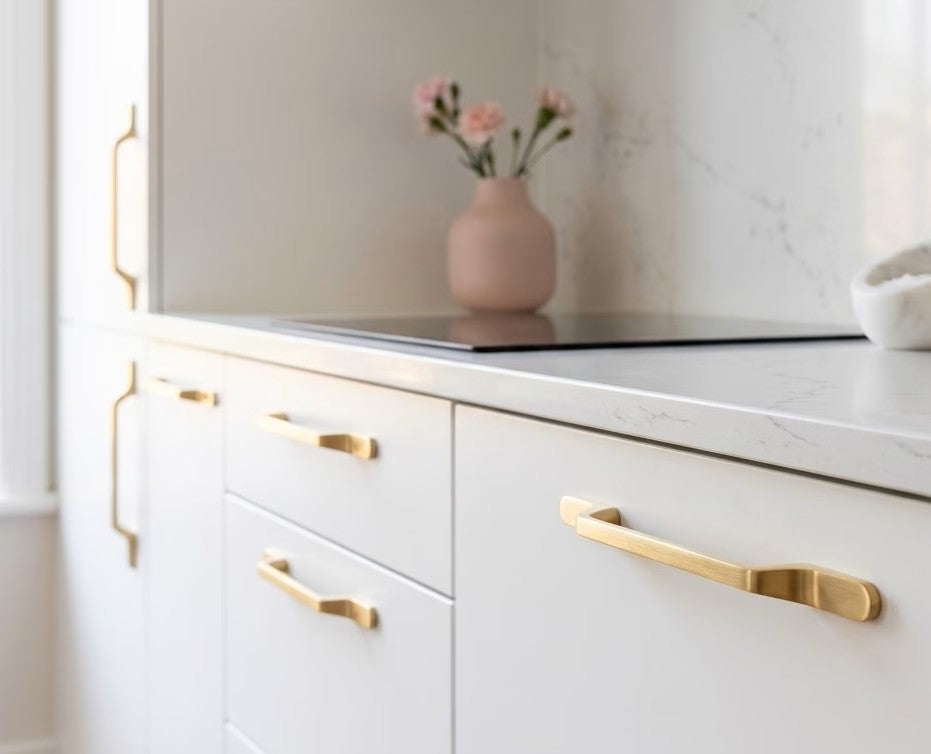 White kitchen cabinets with slimline brushed gold handles in modern kitchen setting