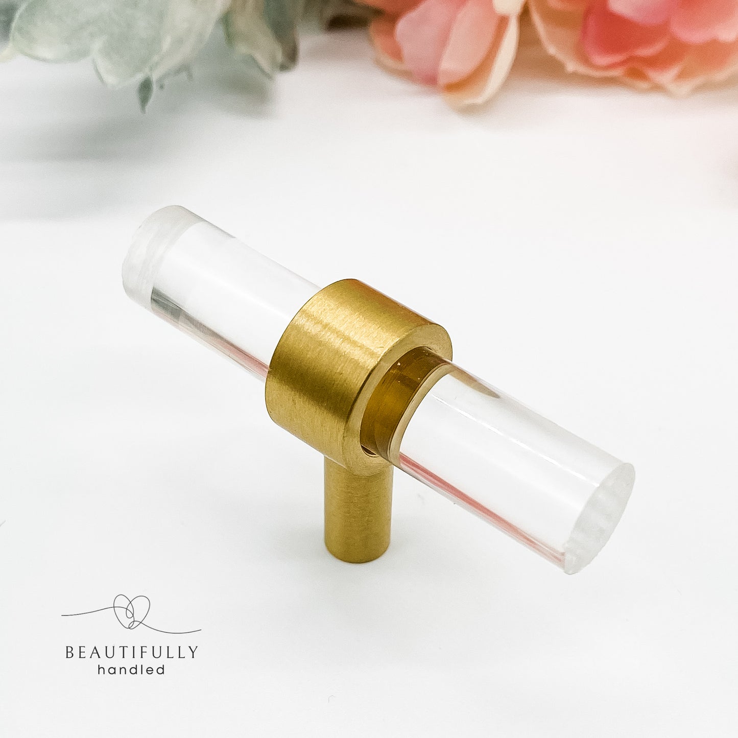 clear drawer handle t-bar with brass foot on white background