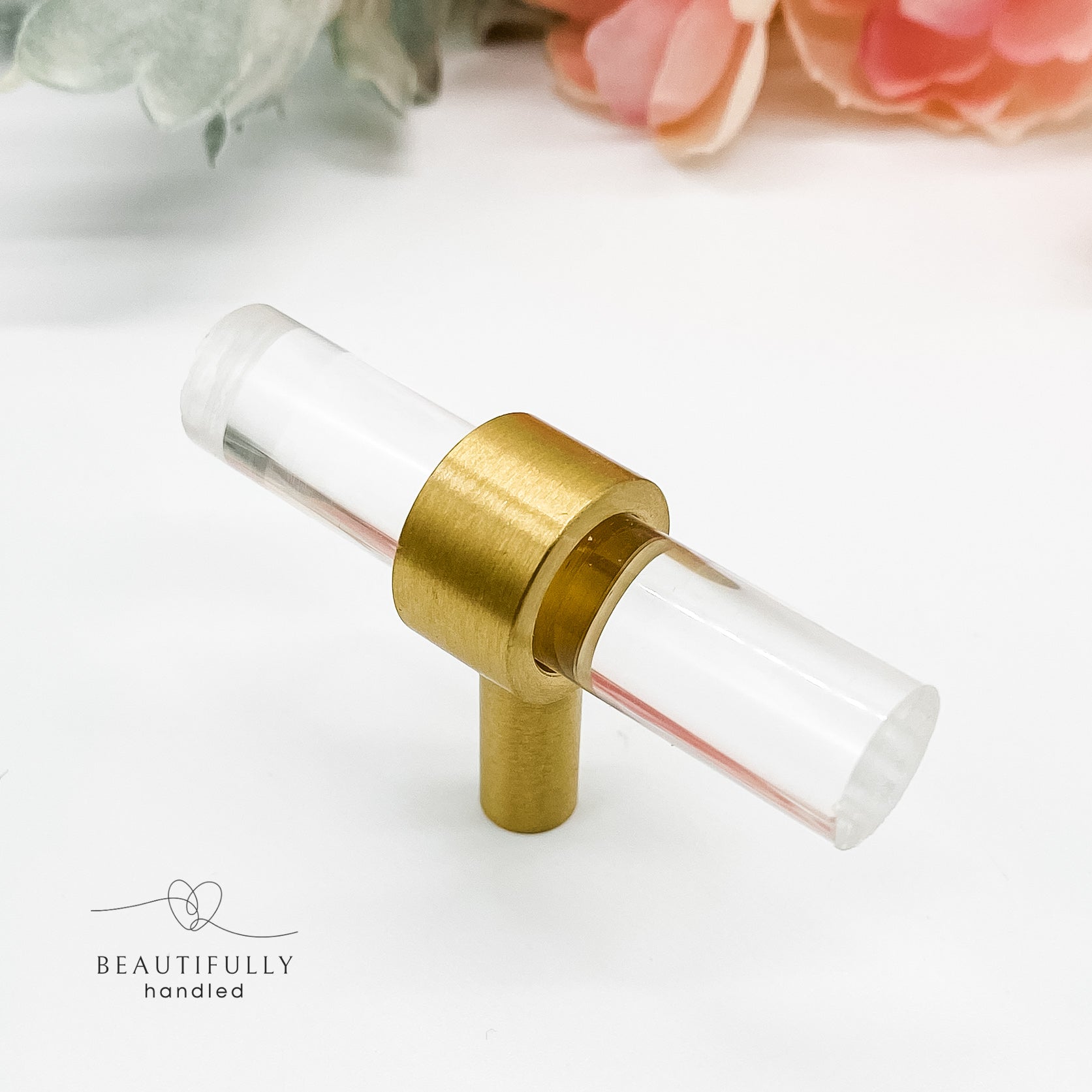 clear drawer handle t-bar with brass foot on white background