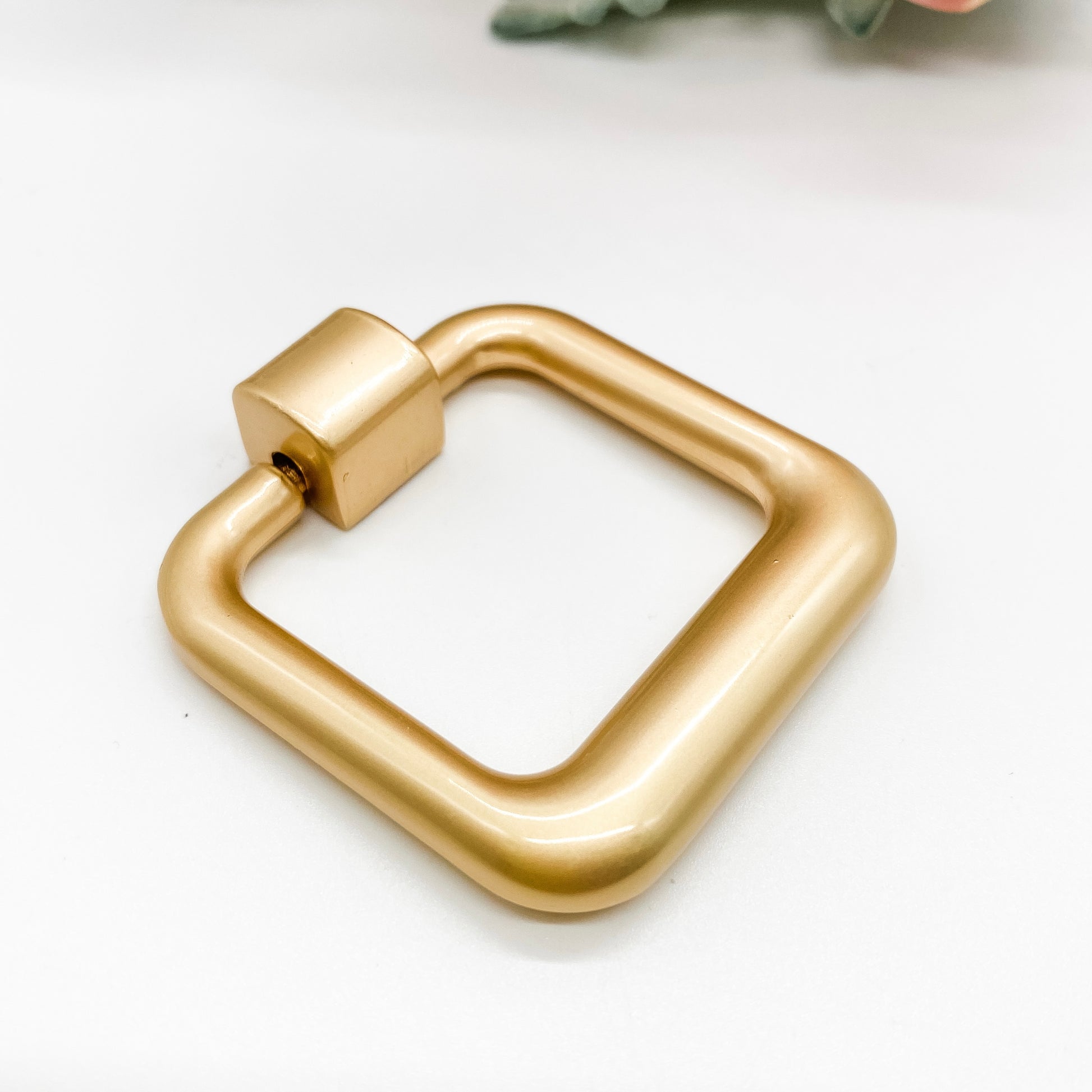 Gold square drop pull handle on white background