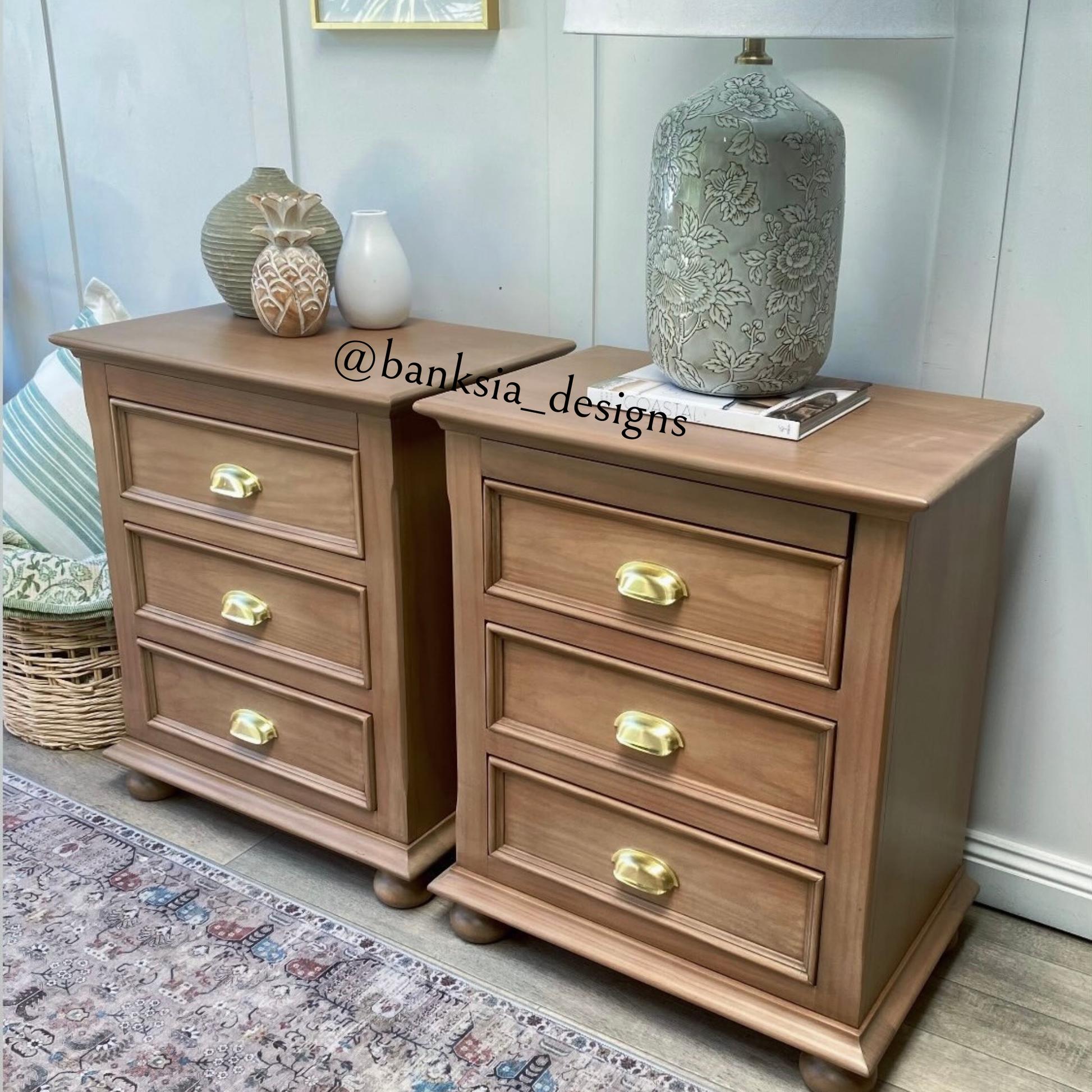 Wooden dresser with gold cup pull handles in a room setting, featuring decorative vases and a lamp.
