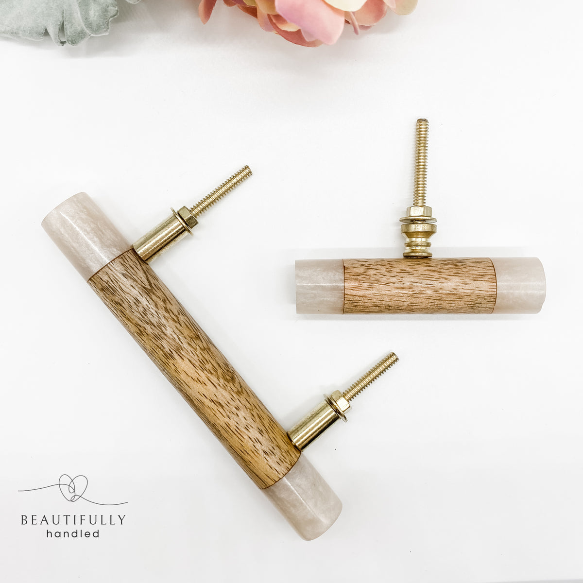 A timber drawer pull handle and matching t-bar featuring a light beige resin casing and a natural wood center inlay, with two brass mounting posts.