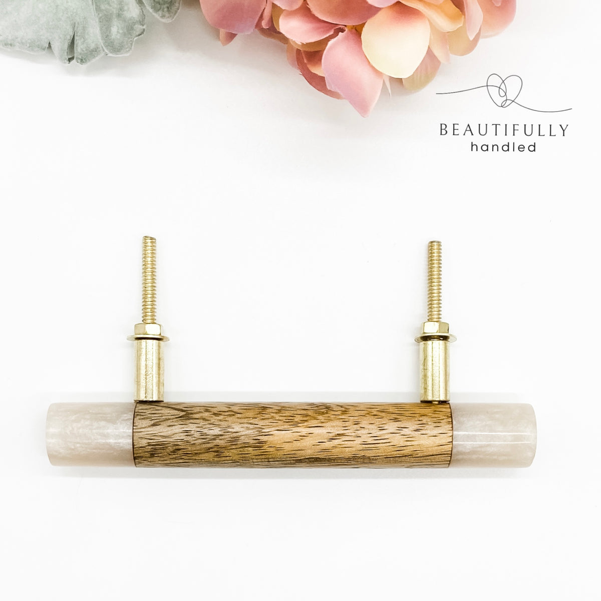 Timber and resin drawer handle on white background with brass bolts