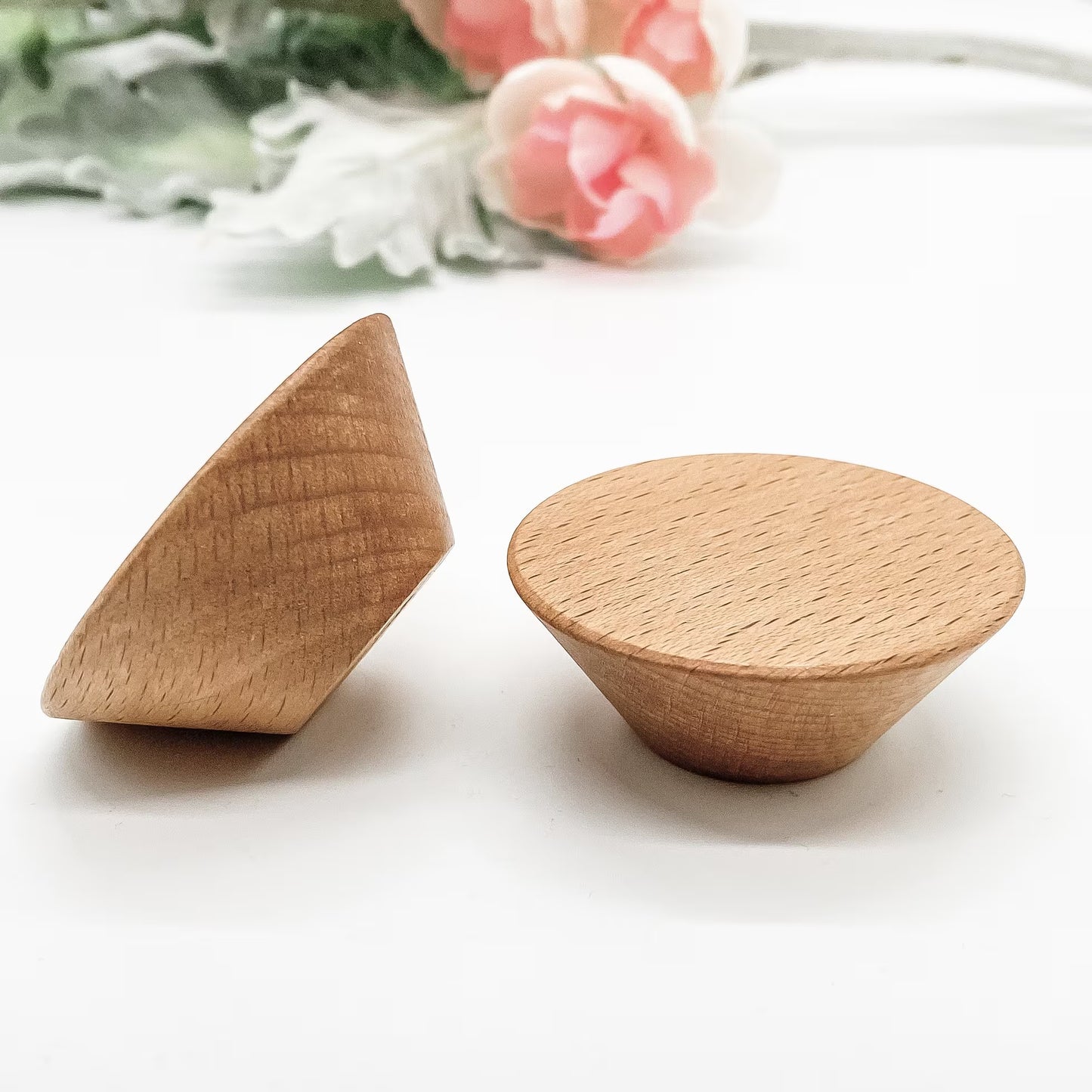 Two wooden drawer knobs mid century style on a white surface 