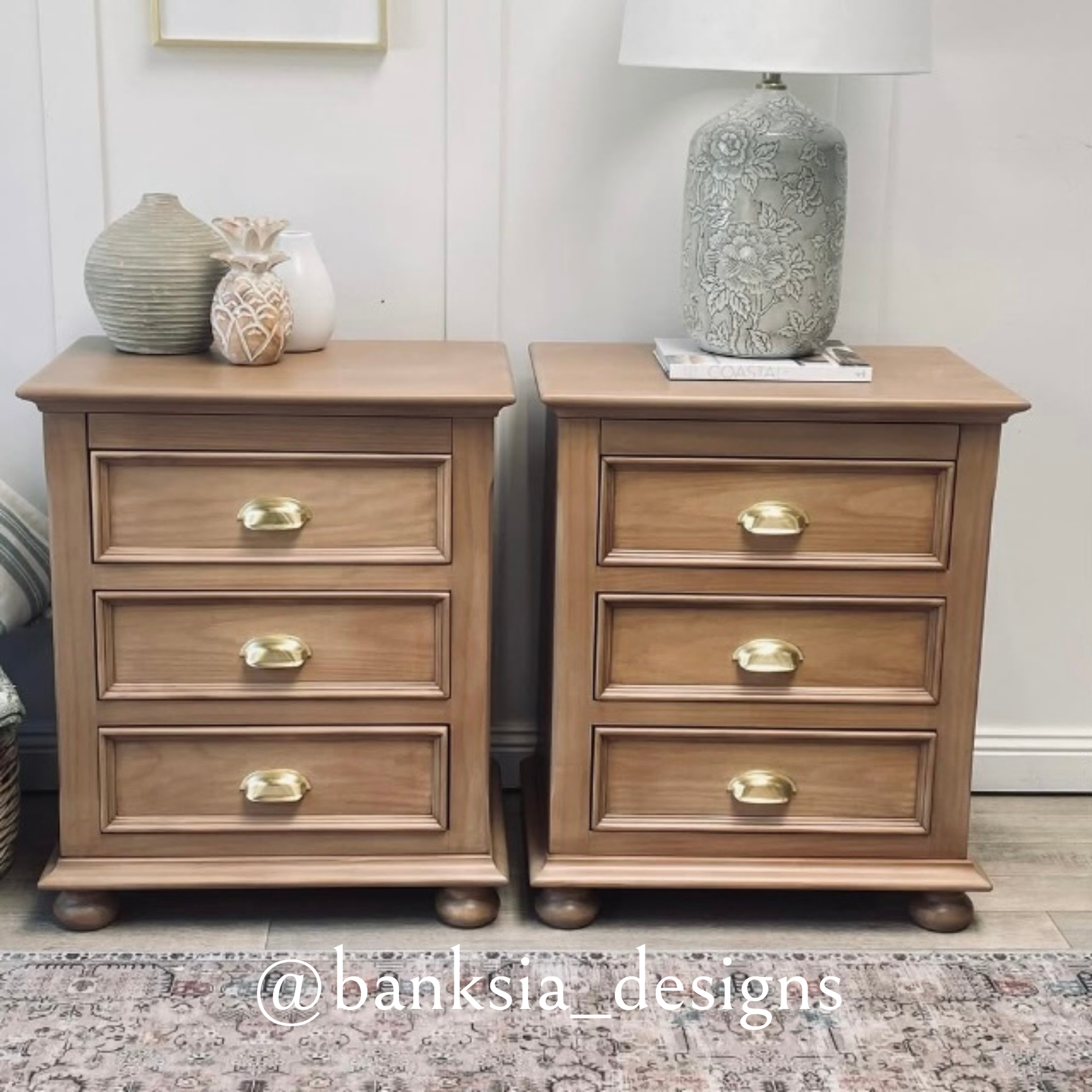 Two wooden nightstands featuring gold cup pull handles in bedroom setting