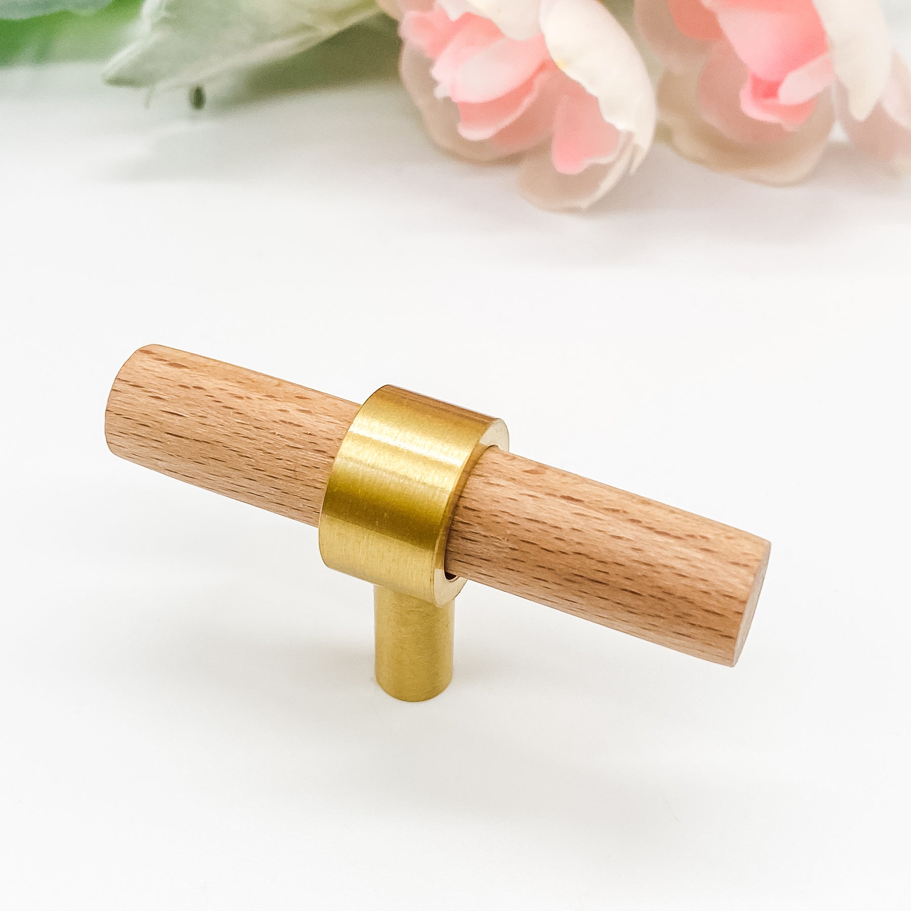 Wooden handle with gold ring on a white background