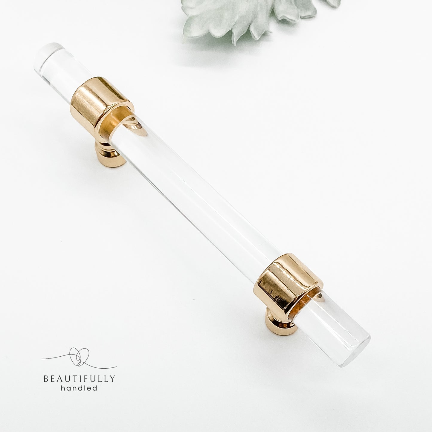 96mm clear acrylic with gold clasp drawer handle on plain white background