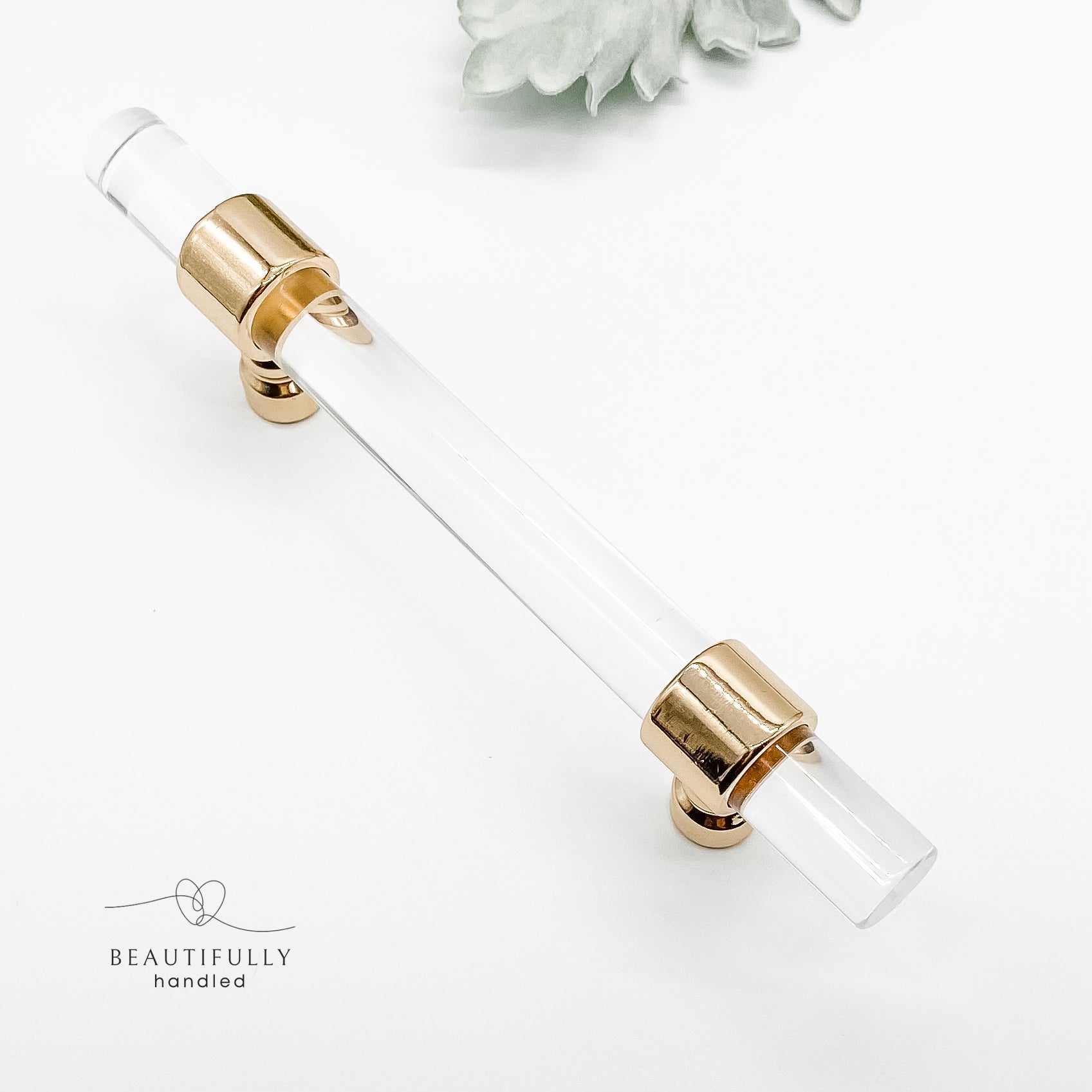 96mm clear acrylic with gold clasp drawer handle on plain white background