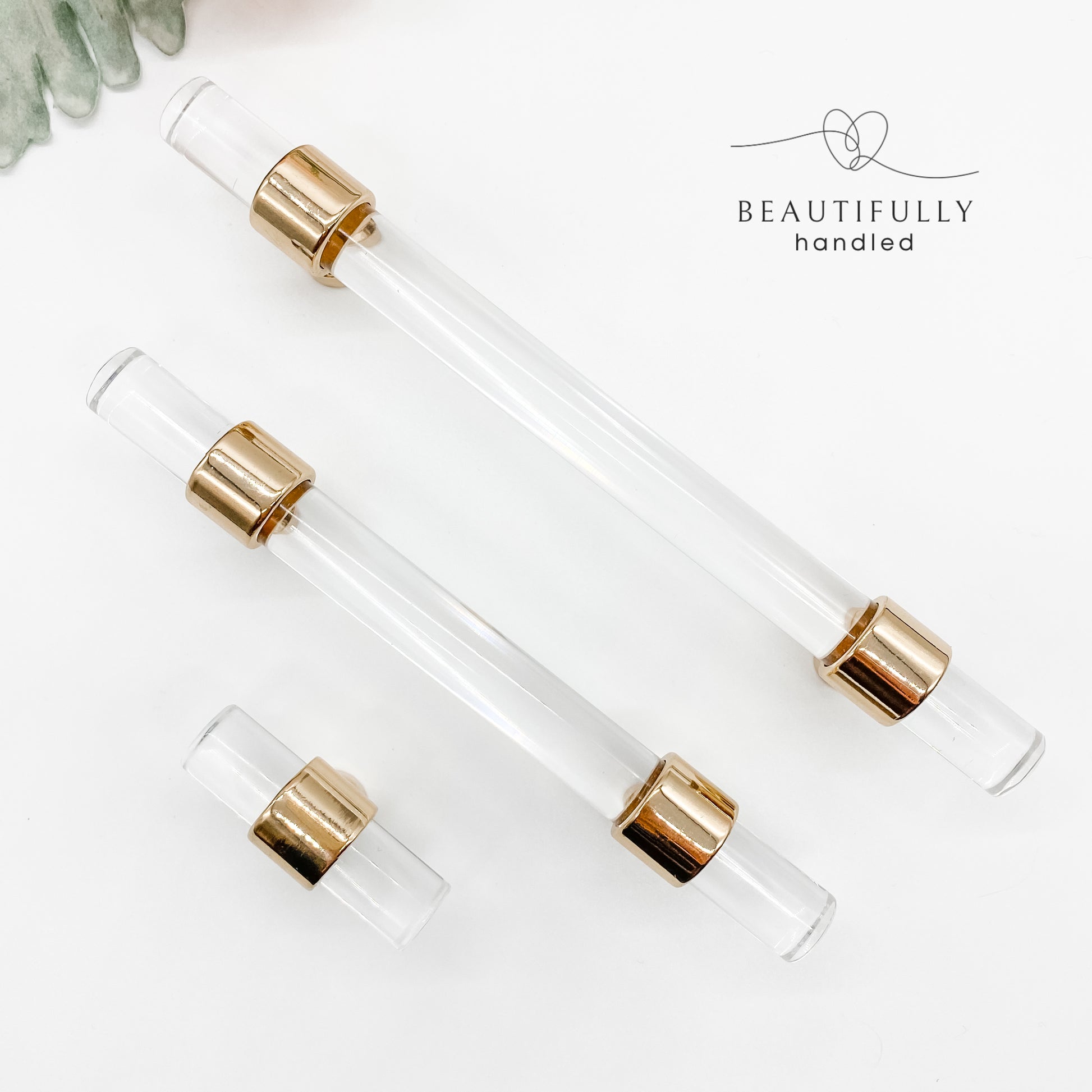 3 sizes of clear acrylic drawer handles with gold clasps on plain white background
