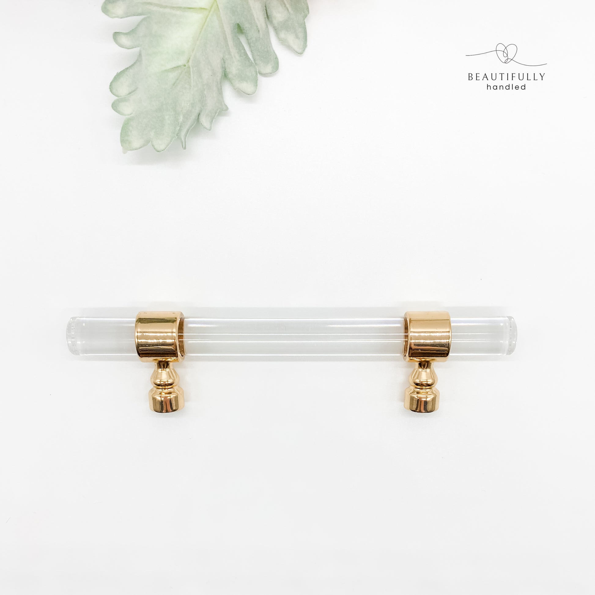 96mm clear acrylic with gold clasp drawer handle on plain white background