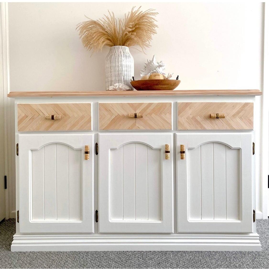 white and timber 3 door buffet featuring rattan tbar handles against white wall