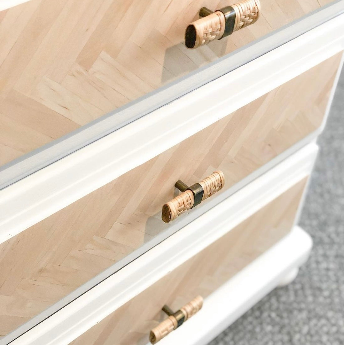 close up of rattan drawer handles on white and timber bedside tables